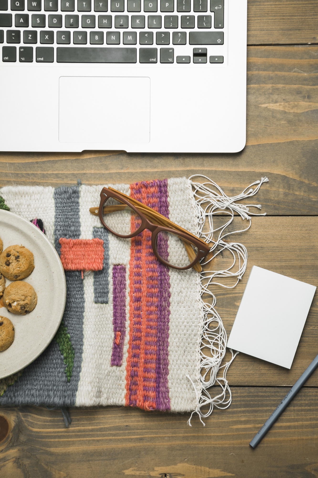 Large editorial shot of embroidered sampler on wooden table